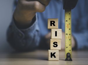 Businessman using tape measure with risk wording for risk analysis investigate management and assessment concept.