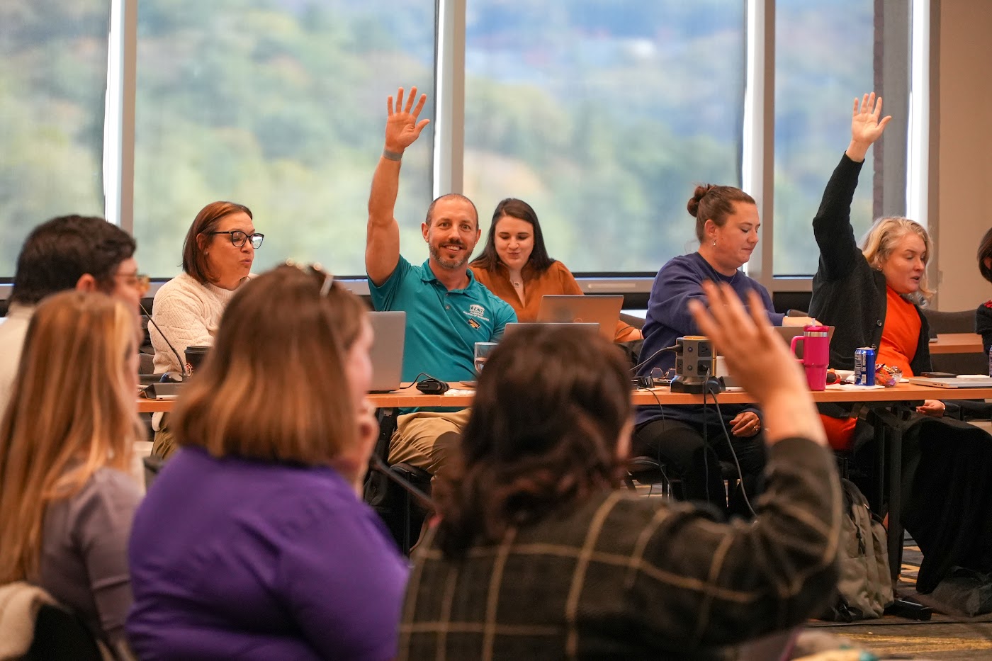 Delegates raise their hands during a vote at the October 2026 Staff Assembly meeting
